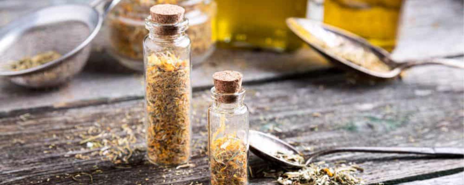 Gyógynövények és természetes olajok kis üvegekben egy fából készült asztalon – a természetes hatóanyagok és gyógyító összetevők fontos szerepet játszanak az egészséges kutya életében.